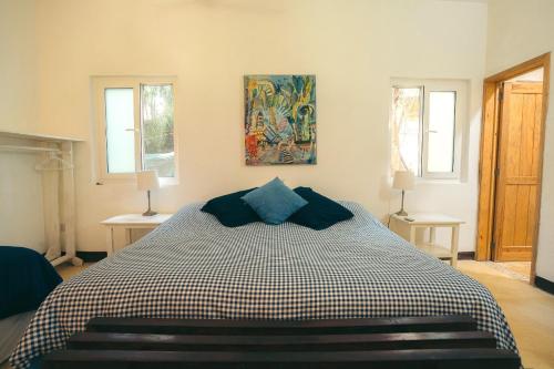 a bedroom with a black and white bed with two windows at Junto al Rio Bungalows & Suites in Sayulita