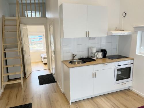 uma cozinha com armários brancos e um lavatório em Newly built Attefall house located in Tumba just outside Stockholm em Tumba