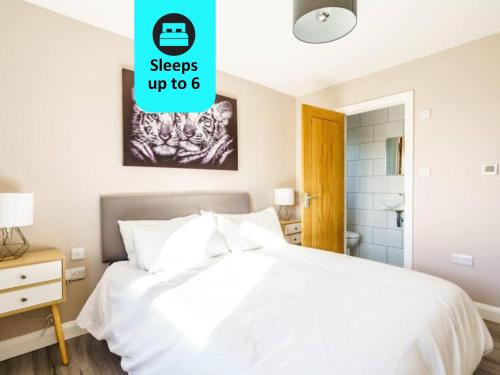 1 dormitorio con cama blanca y baño en The Oak View: Haven Retreat in Bristol Countryside, en Wrington