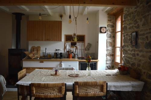 une cuisine avec une table et des chaises et une cuisine avec un comptoir dans l'établissement La Fabrique du Ronçon, à Saint-Bonnet-le-Troncy