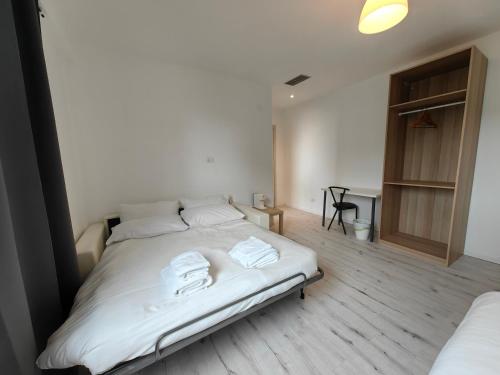 a bedroom with a white bed with towels on it at MILANFORESTER in Milan