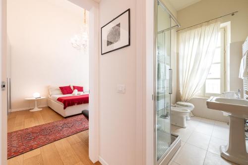 a living room with a couch and a bathroom at Chic Elegance at Borgo Tommasini Apartment in Parma