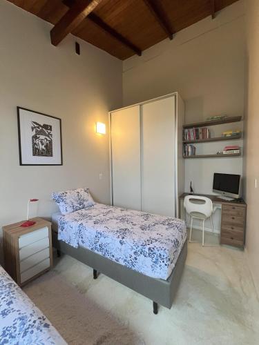 a bedroom with a bed and a desk with a computer at Pariká Pousada in Alto Paraíso de Goiás
