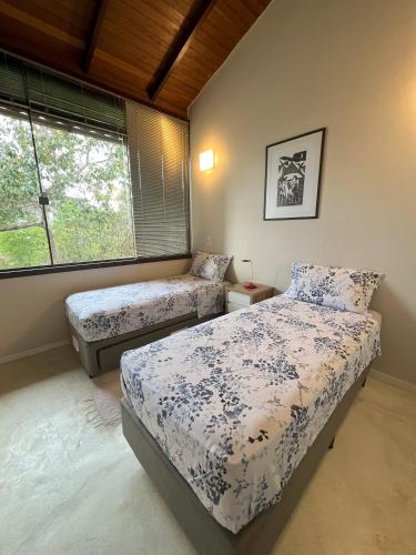 a bedroom with two beds and a window at Pariká Pousada in Alto Paraíso de Goiás