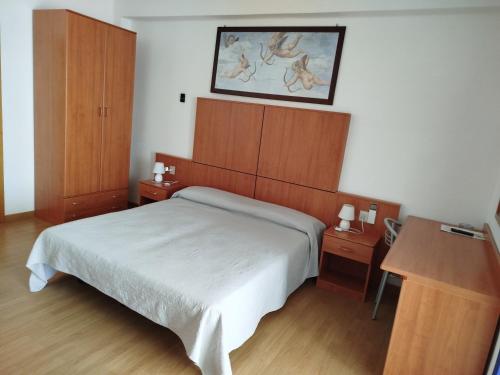 1 dormitorio con 1 cama y 2 armarios de madera en Hotel Silva Frontemare, en Lido di Jesolo