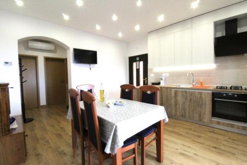 een keuken met een tafel en stoelen in een kamer bij Apartments Tre pini in Umag