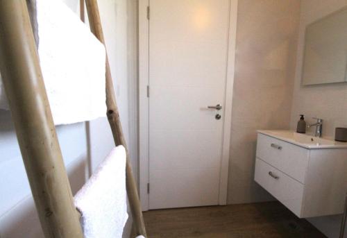 a bathroom with a white door and a sink at Villa MARES in Umag