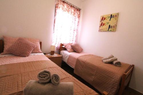 a bedroom with two beds and a window at Apartments Tre pini in Umag
