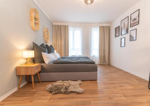 a bedroom with a bed and a wooden floor at Barrierefrei I free parking I Terasse I Netflix in Quedlinburg