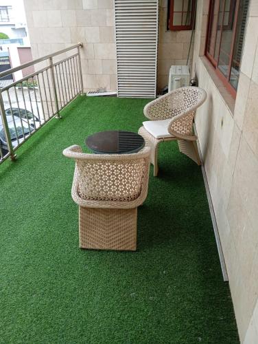 a patio with a grill and two chairs on a balcony at Sujimoto Shortlet Ave Forche, Banana Island, Ikoyi in Ikoyi