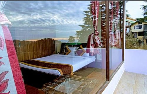 1 dormitorio con 1 cama en el balcón en Sun set retreat, en Shimla