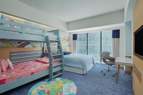 a bedroom with two bunk beds and a desk at Four Points by Sheraton Surabaya, Tunjungan Plaza in Surabaya