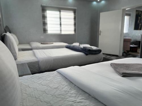 a bedroom with three beds and a window at Petra Pillars Way Hostel in Wadi Musa