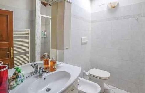 a white bathroom with a sink and a toilet at Casa Vicolo Lugnano in Città di Castello