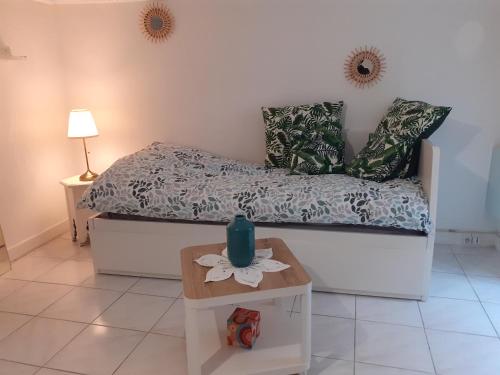 - une chambre avec un lit et une table avec un vase dans l'établissement Studio neuf centre ville Quartier Libération, à Nice