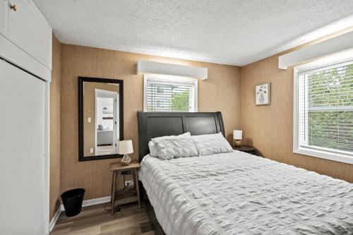 a bedroom with a large bed and two windows at Peach Street Super Suite in Medford