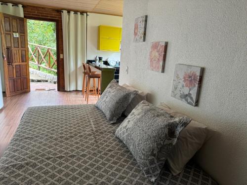 um quarto com uma cama com duas almofadas em Chalé 10 até 4 pessoas cozinha próx ao centro em Itatiaia