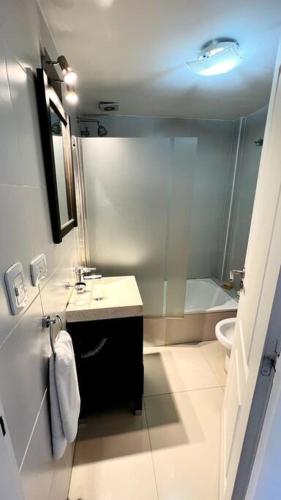 een badkamer met een douche, een wastafel en een toilet bij Luminoso departamento en Castelar centro p/2 pers in Castelar