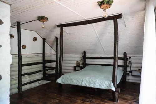 a bedroom with a four poster bed and a staircase at База відпочинку Forest Stream in Svalyava