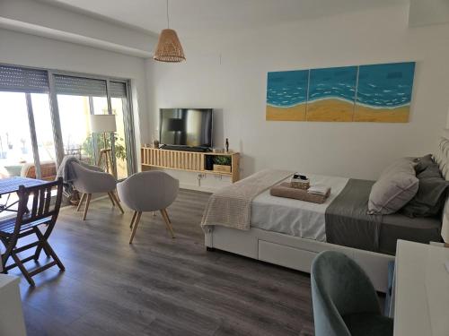 una camera da letto con un letto, un tavolo e delle sedie di Sesimbra Cliffs OceanView - 5min walk to Beach a Sesimbra