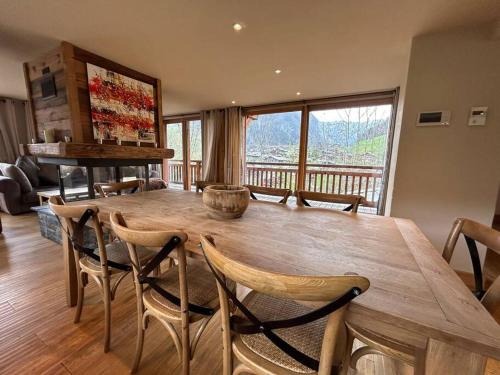 Una sala de estar con una gran mesa y sillas de madera. en Chalet Rose, en Morzine