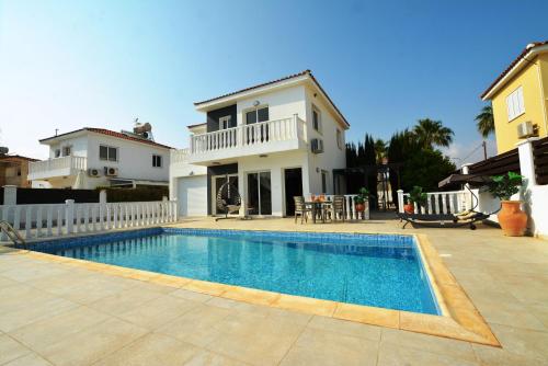 a villa with a swimming pool in front of a house at Villa Thetida in Ayia Napa