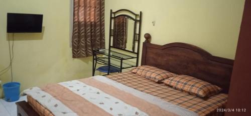 sypialnia z drewnianym łóżkiem i lustrem w obiekcie Istana Griya 1 w mieście Surakarta