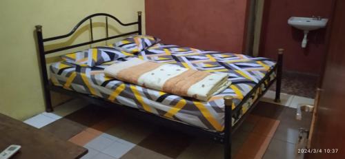 łóżko z kołdrą i umywalką w obiekcie Istana Griya 1 w mieście Surakarta
