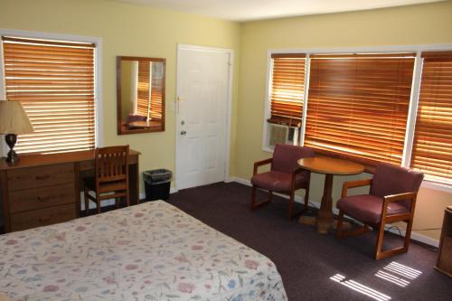 a bedroom with a bed and a table and chairs at Crest Motel in Bartlett
