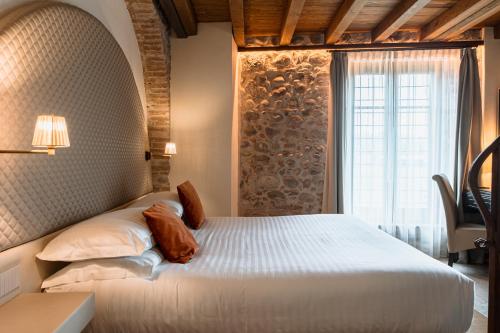 a bedroom with a white bed with a window at Corte Regia Relais & Spa in Valeggio sul Mincio