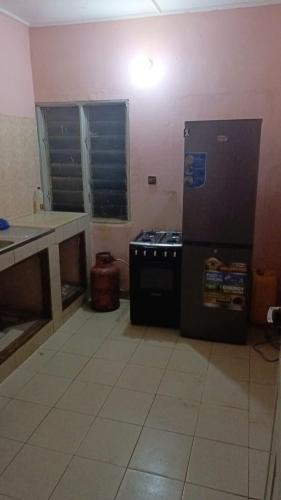 a kitchen with a refrigerator and a stove in it at ABZ GUEST HOUSE in Abomey