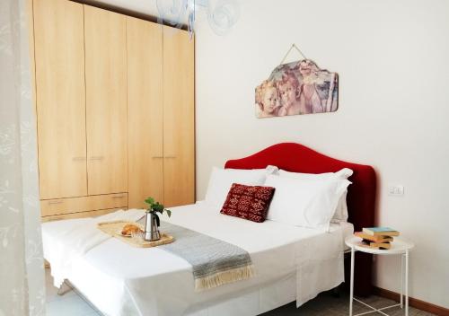 a bedroom with a white bed with a red headboard at Holihome_C&C Sunrise House in Tortoreto Lido