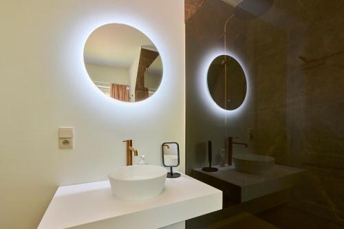 a bathroom with a white sink and two mirrors at Villa Bosrijk in Lommel