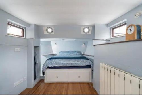 um quarto com uma cama no meio de um quarto em Historic Dutch Barge, Idyllic location em Londres
