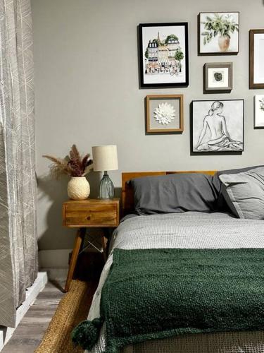 a bedroom with a bed and framed pictures on the wall at Boho Bungalow near TU/DT/Cherry St/Expo Center in Tulsa