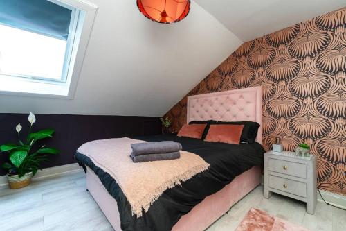 1 dormitorio con 1 cama grande y cabecero rosa en The Glasgow Rose- Stylish Penthouse 2 Bed City Centre Apartment with Free Parking & Lift en Glasgow