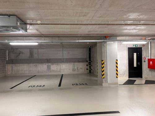an empty parking garage with a black door in it at Apartment Zwirn, free parking, 24/7 access in Nivy