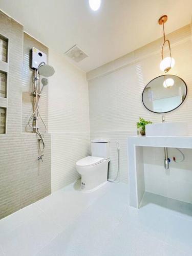 a bathroom with a toilet and a sink and a mirror at Monoji House - บ้านพักในสันติธรรมพร้อมไวไฟ in Chiang Mai