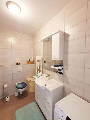 a white bathroom with a sink and a toilet at Apartment Felix in Rijeka