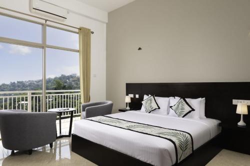 um quarto com uma cama grande e uma varanda em Hill Paradise Hanthana em Kandy
