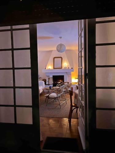- un salon avec une cheminée, une table et des chaises dans l'établissement Agréable Maison Landaise proche du Lac, à Sanguinet