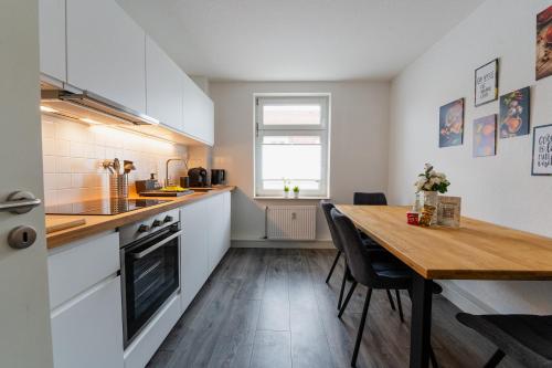 cocina con mesa de madera y comedor en Luxury Vista Apartment I Küche I WLAN I Smart-TV, en Magdeburgo