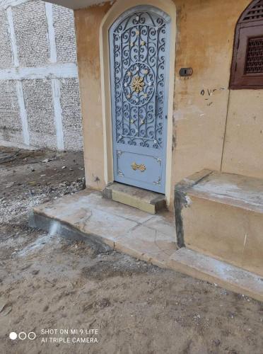 eine blaue Tür an der Seite eines Gebäudes in der Unterkunft Seif Kabir guest studio in Nag` el-Ramla
