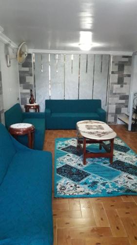 a living room with a blue couch and a coffee table at Seif Kabir guest studio in Nag` el-Ramla