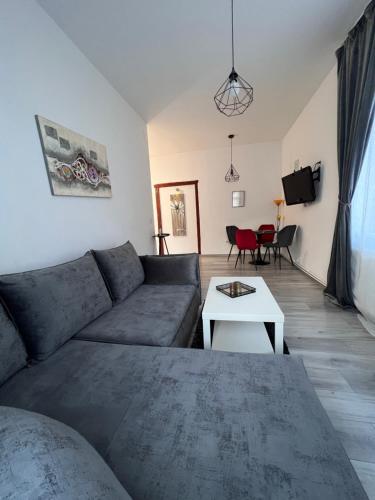 ein Wohnzimmer mit einem Sofa und einem Tisch in der Unterkunft Apart City Center in Braşov