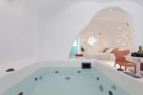 a bathtub in a living room with a couch at Naxos Cave Suites in Stelida
