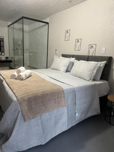 sypialnia z dużym łóżkiem z ręcznikami w obiekcie Chalé 01 com hidro e cozinha no coração de Penedo w mieście Itatiaia