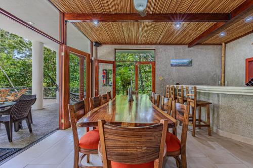 a dining room with a long table and chairs at The Jungle Inn in Dominicalito
