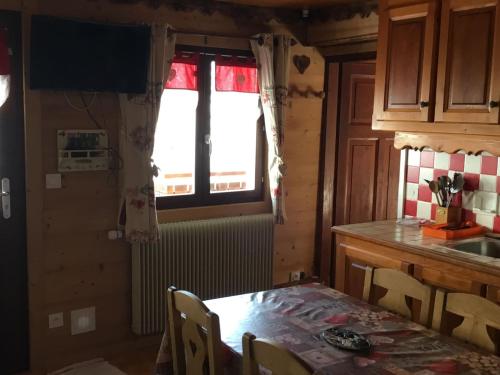 une cuisine avec une table et une fenêtre dans l'établissement Appartement 3 pièces avec balcon, proche des remontées mécaniques et du centre, parking inclus - FR-1-676-56, à Châtel