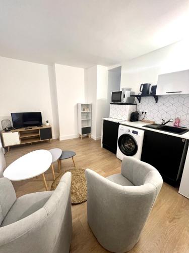 un salon avec une table et des chaises et une cuisine dans l'établissement Place St Epvre - Cosy studio rénové, à Nancy